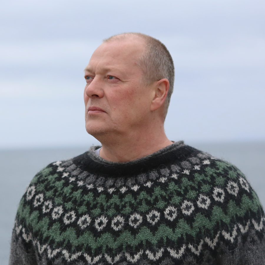 Teitur, the sales and logistics manager, is looking away from the camera, dressed in a traditional islandic knit sweater.
