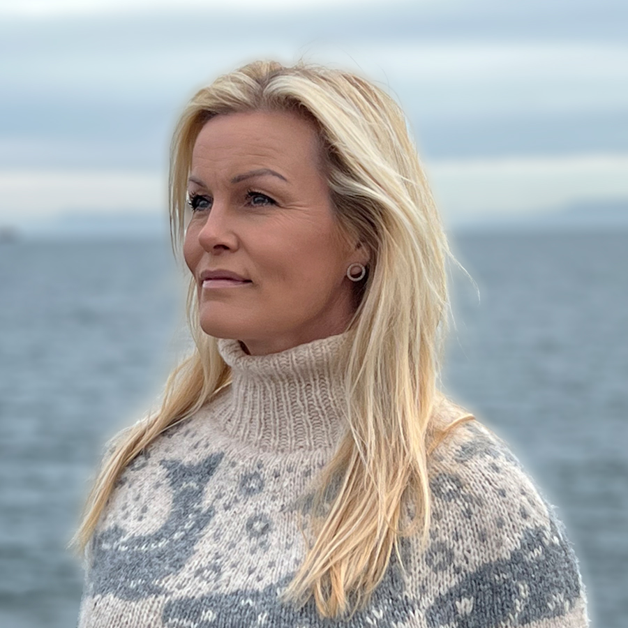 Gudrún, the PA to the CEO, is looking away from the camera, dressed in a traditional islandic knit sweater.